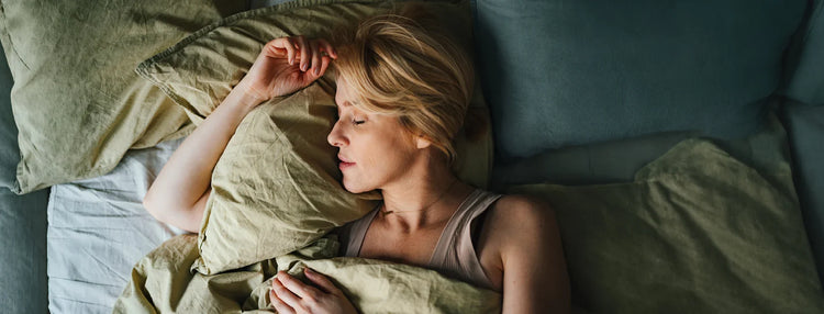 Woman sleeping in green bedding.