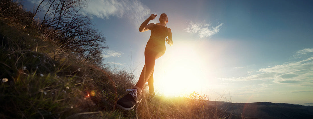 Woman going for a jog in the countryside at sunrise. 