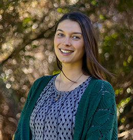 Woman standing outdoors with a blurred natural background