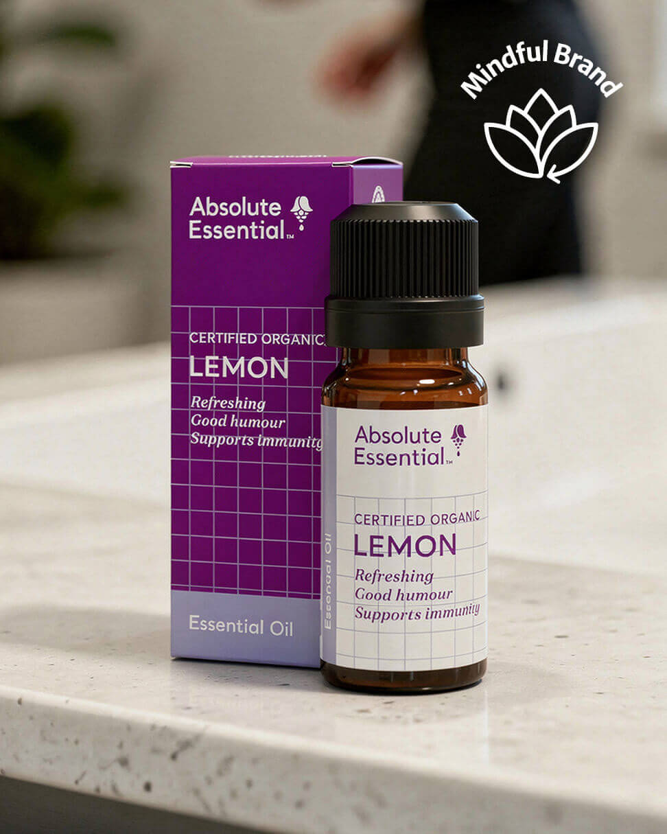 Absolute Essential lemon essential oil bottle and packaging on a marble surface with 'Mindful Brand' logo.