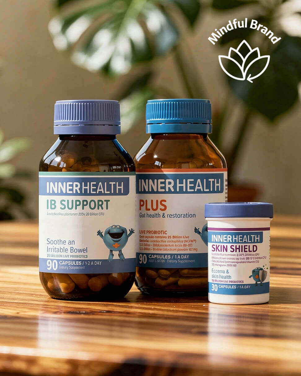 Three Inner Health supplement bottles on a wooden surface with a blurred green plant background.