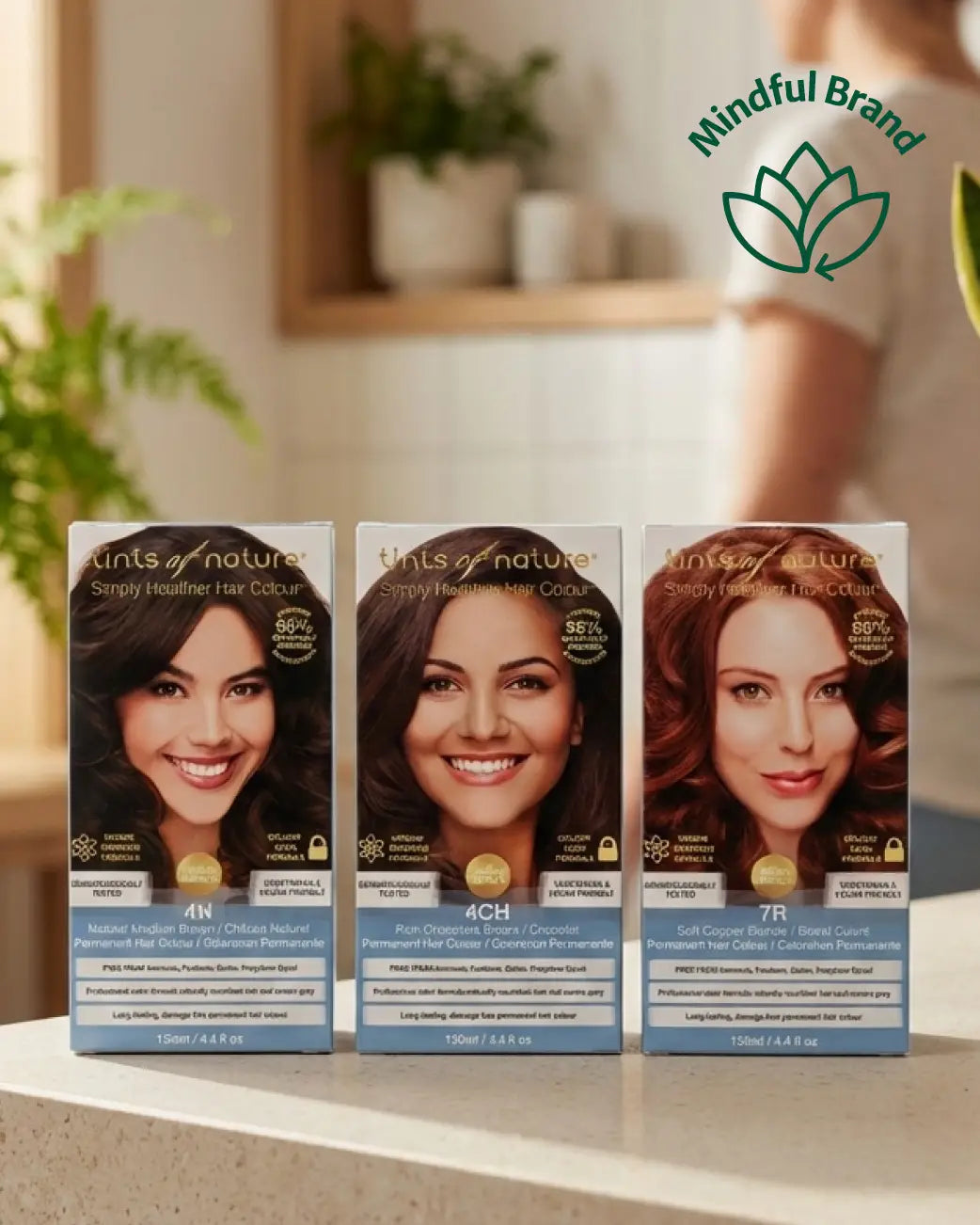 3 Tints of Nature hair dye products displayed on a bench top. Green mindful brand logo in the top corner.