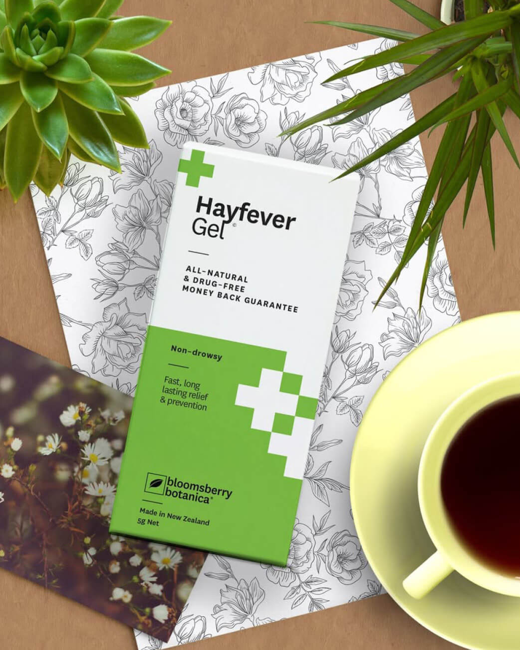 Hayfever Gel packaging with a cup of tea and plants on a floral-patterned surface