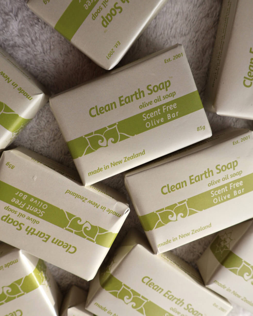 Multiple boxes of Clean Earth Soap on a textured surface