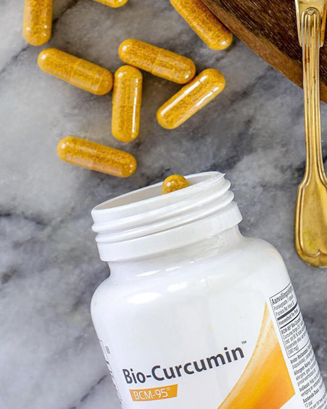 Bio-Curcumin supplement bottle with capsules on a marble surface