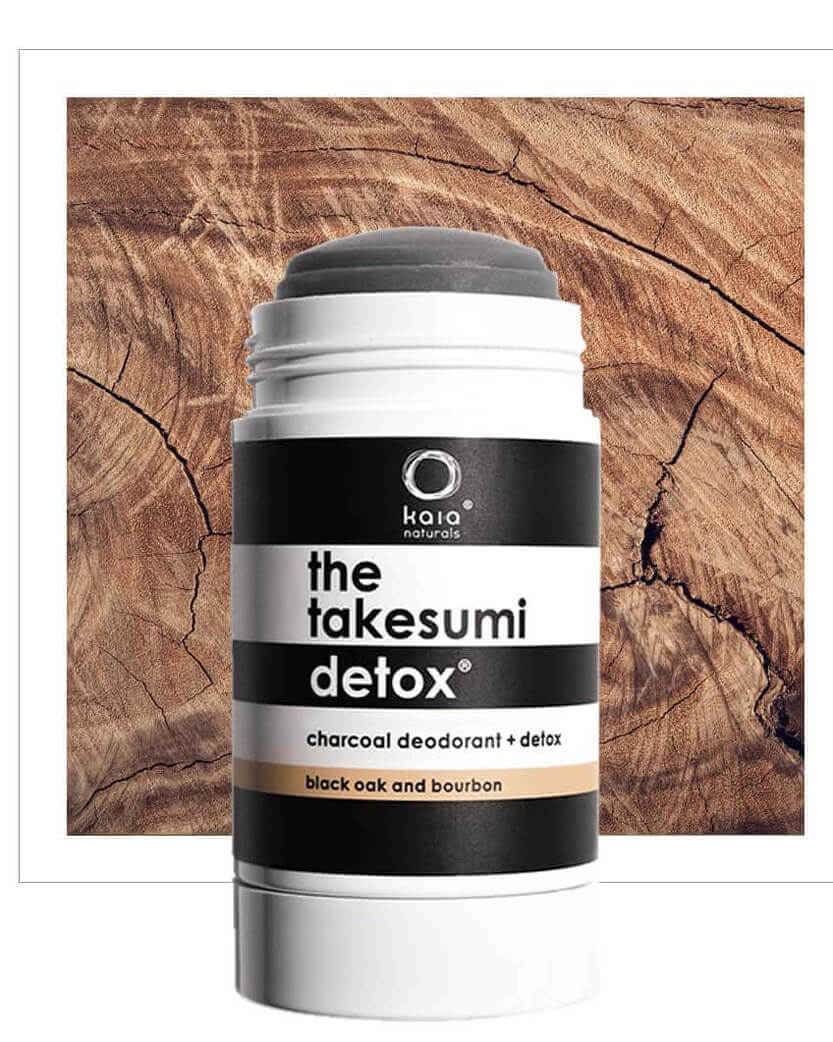 Kaia Naturals takesumidi detox charcoal deodorant stick on a wooden background.