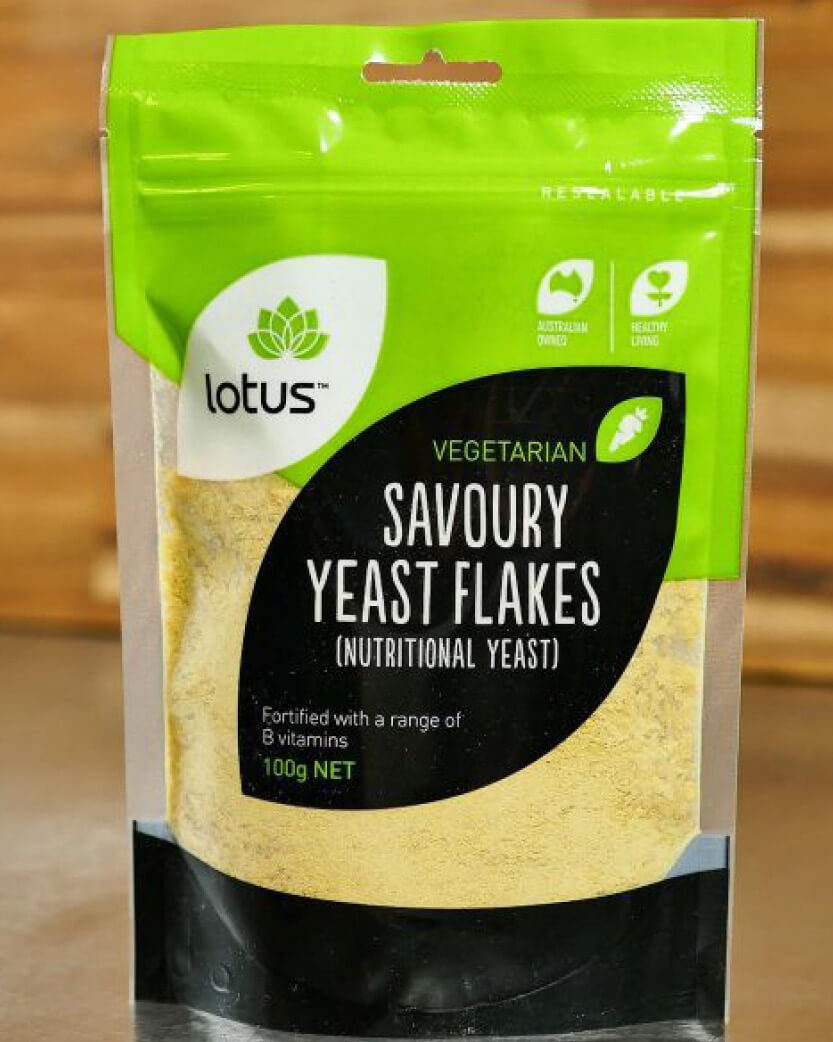 Packaging of Lotus Vegetarian Savoury Yeast Flakes on a wooden surface.