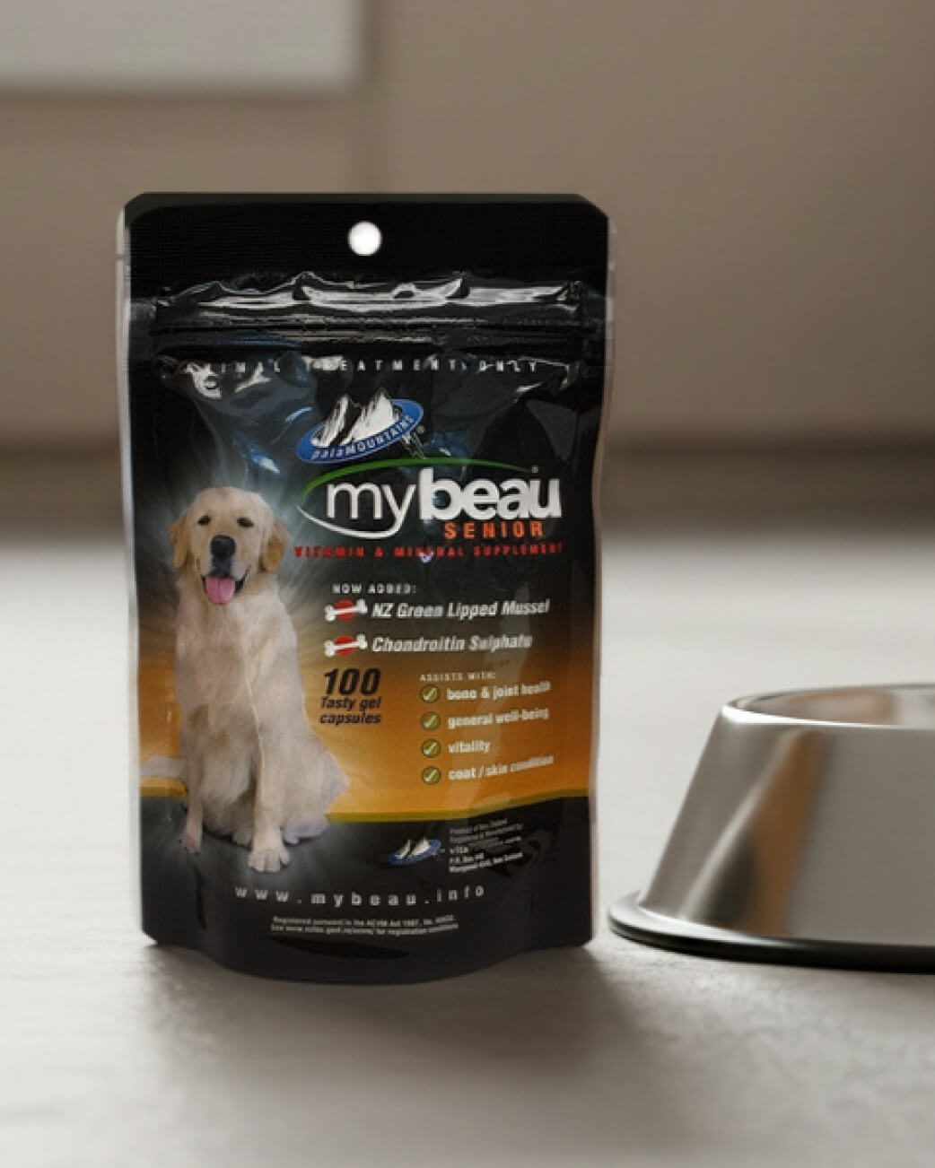 Mybeau senior dog supplement package on a light surface with a metal bowl in the background.