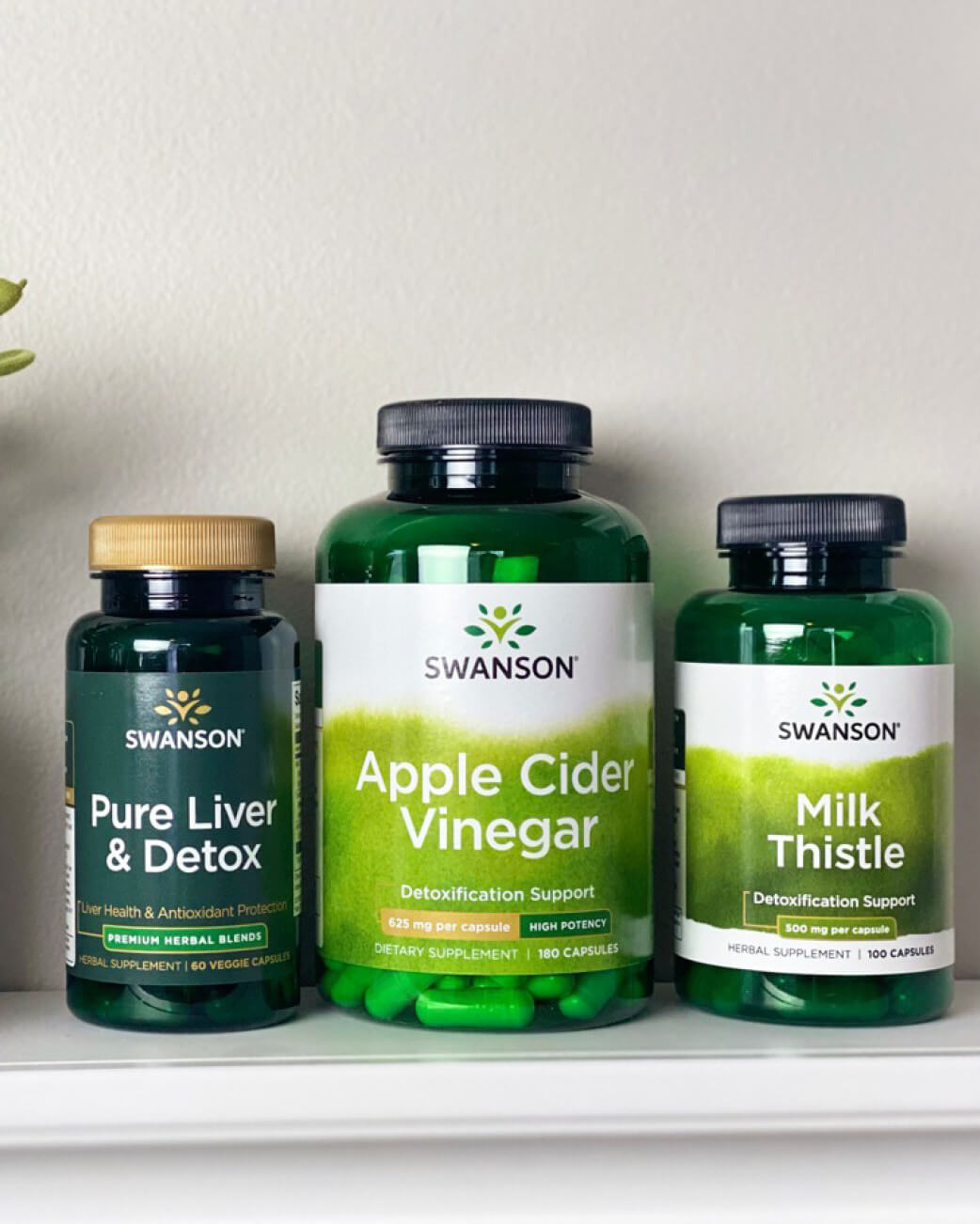 Three Swanson supplement bottles on a white surface with a light grey background.