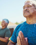 Man in a blue shirt meditating.