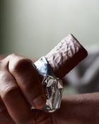 Hand holding a chocolate protein bar.