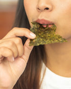 Person eating a seaweed snack