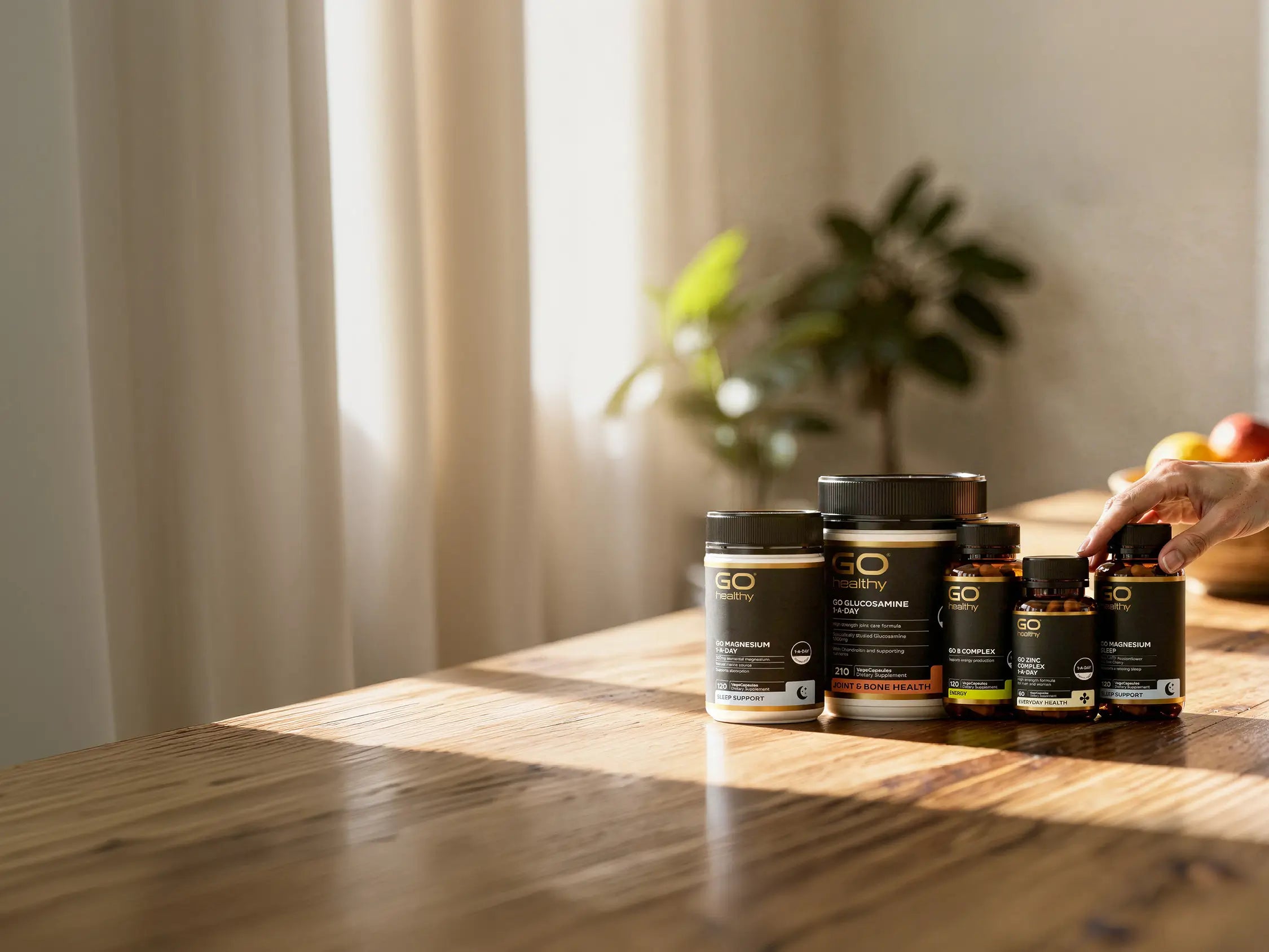 Collection of supplement bottles on a wooden table with a blurred background.