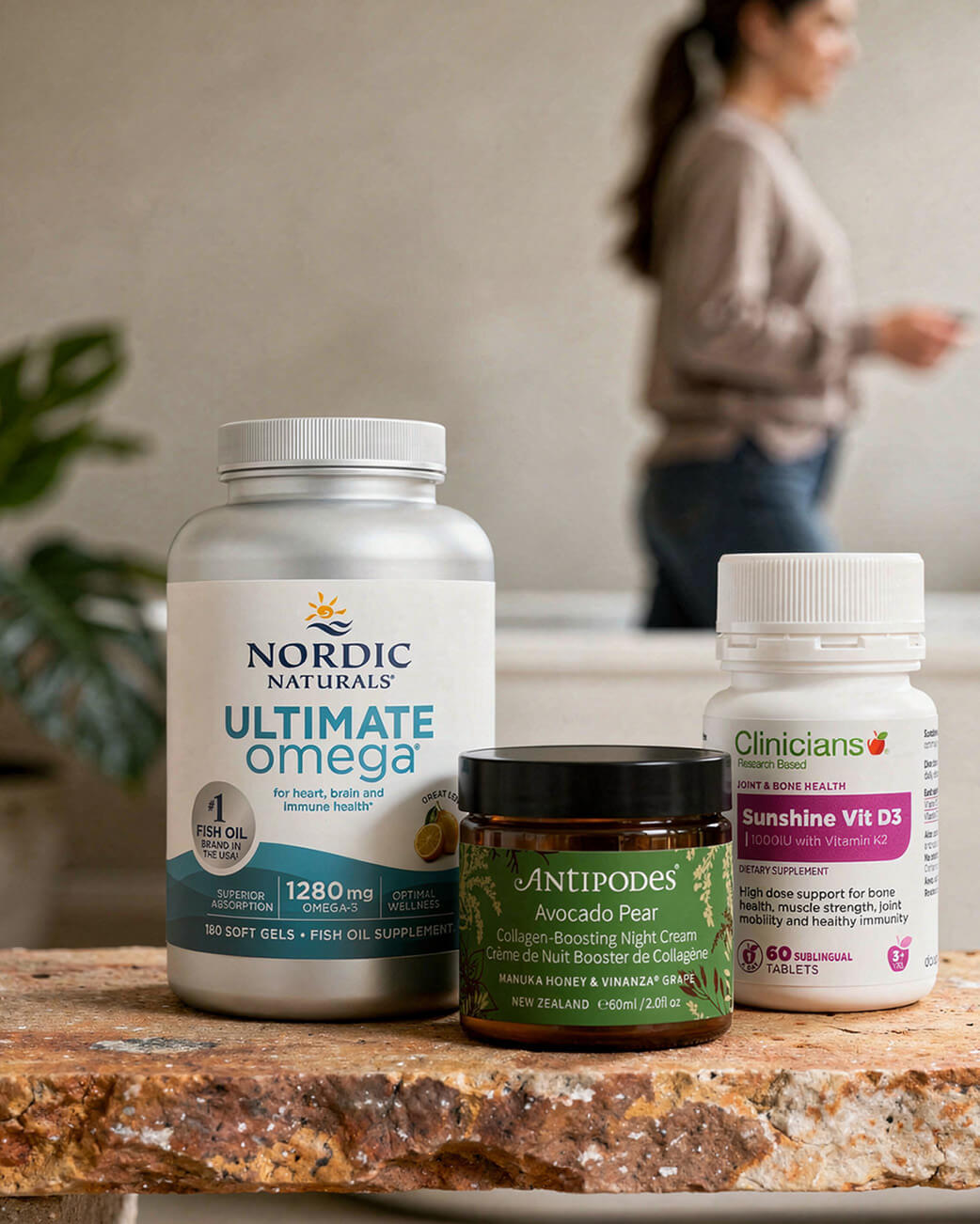 Three health products on a surface with a blurred background of a person and plants.