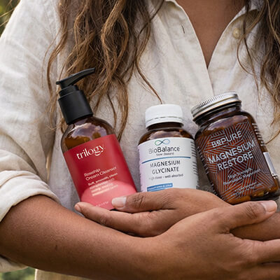 Arms holding three natural health products.