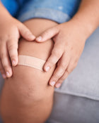 Person applying a bandage to a knee injury.