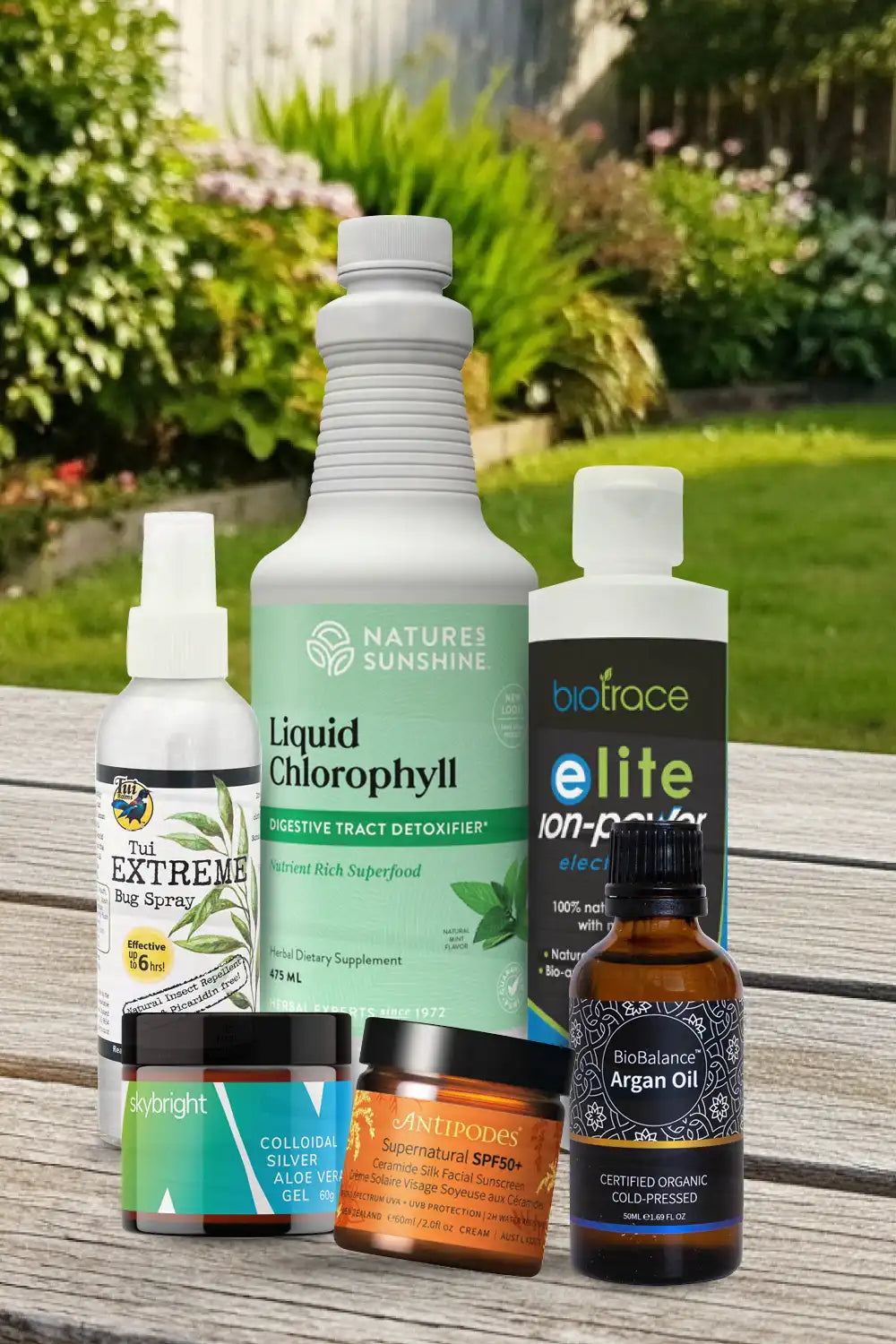 Collection of health and wellness products on a wooden surface with a garden background.