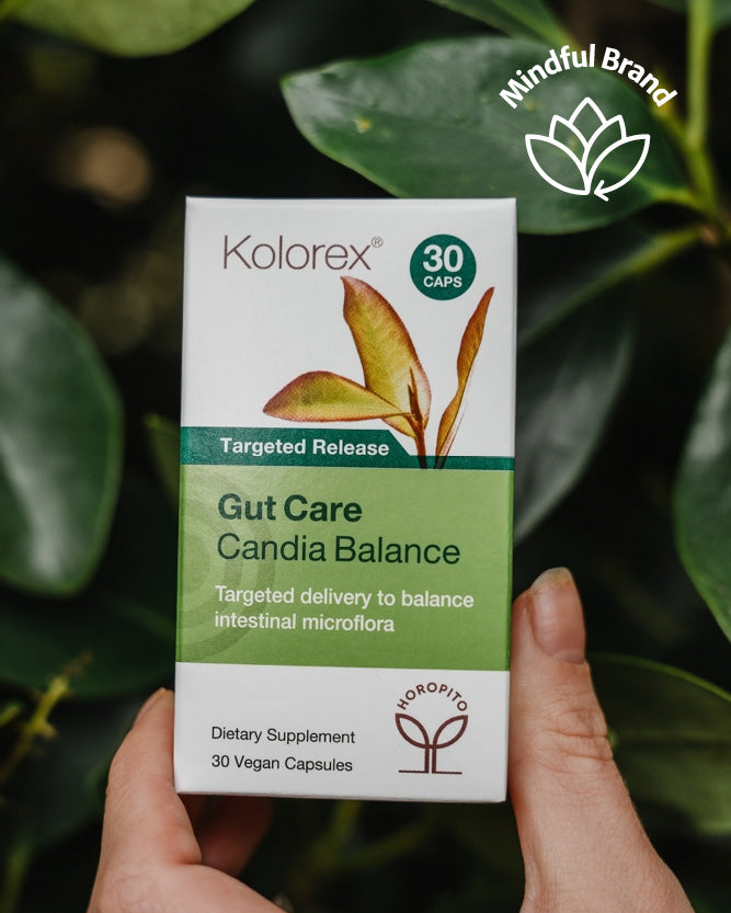 Kolorex Gut Care Candida Balance supplement box held in front of green leaves
