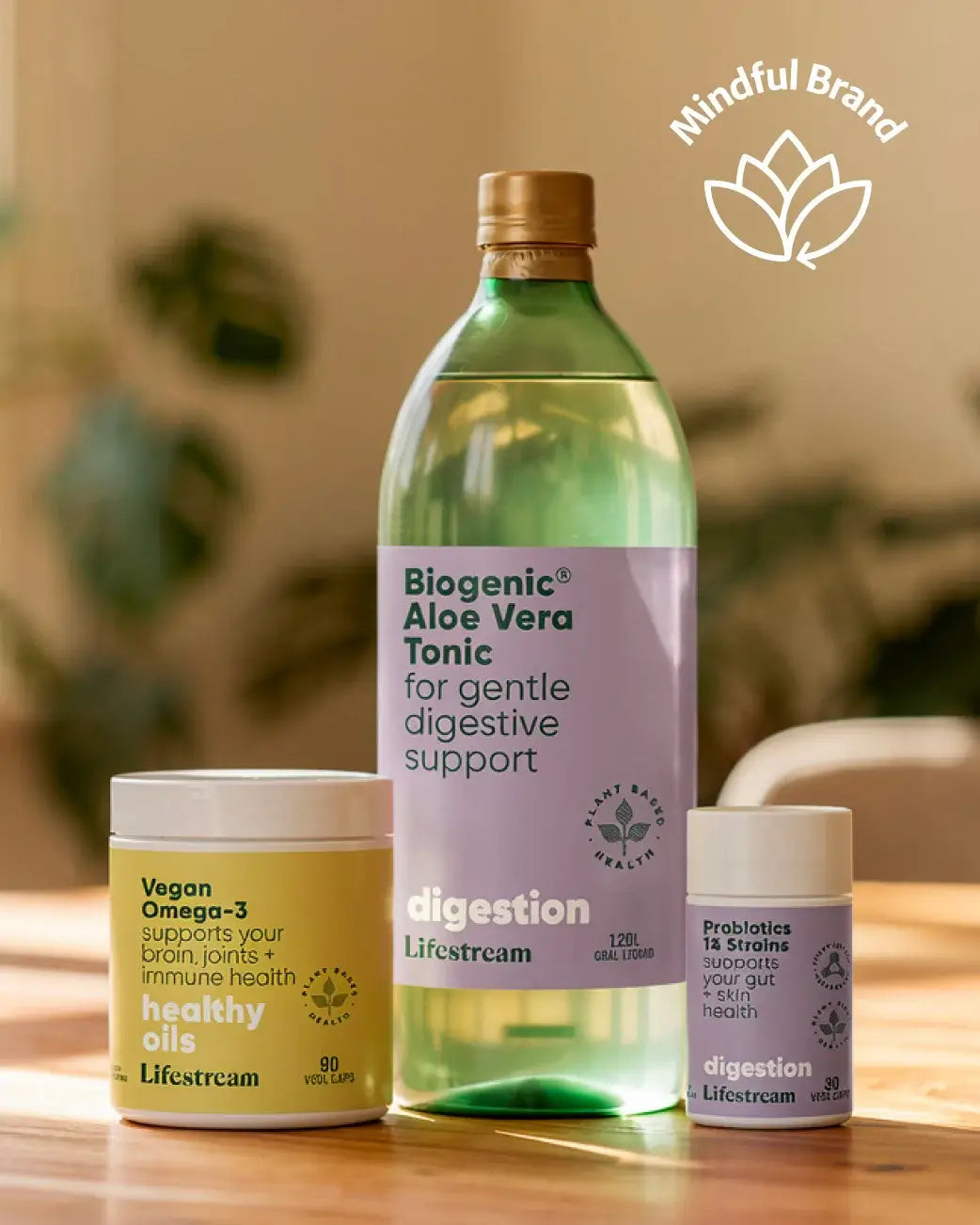 Biogenic Aloe Vera Tonic and other health products on a wooden surface with a blurred background.