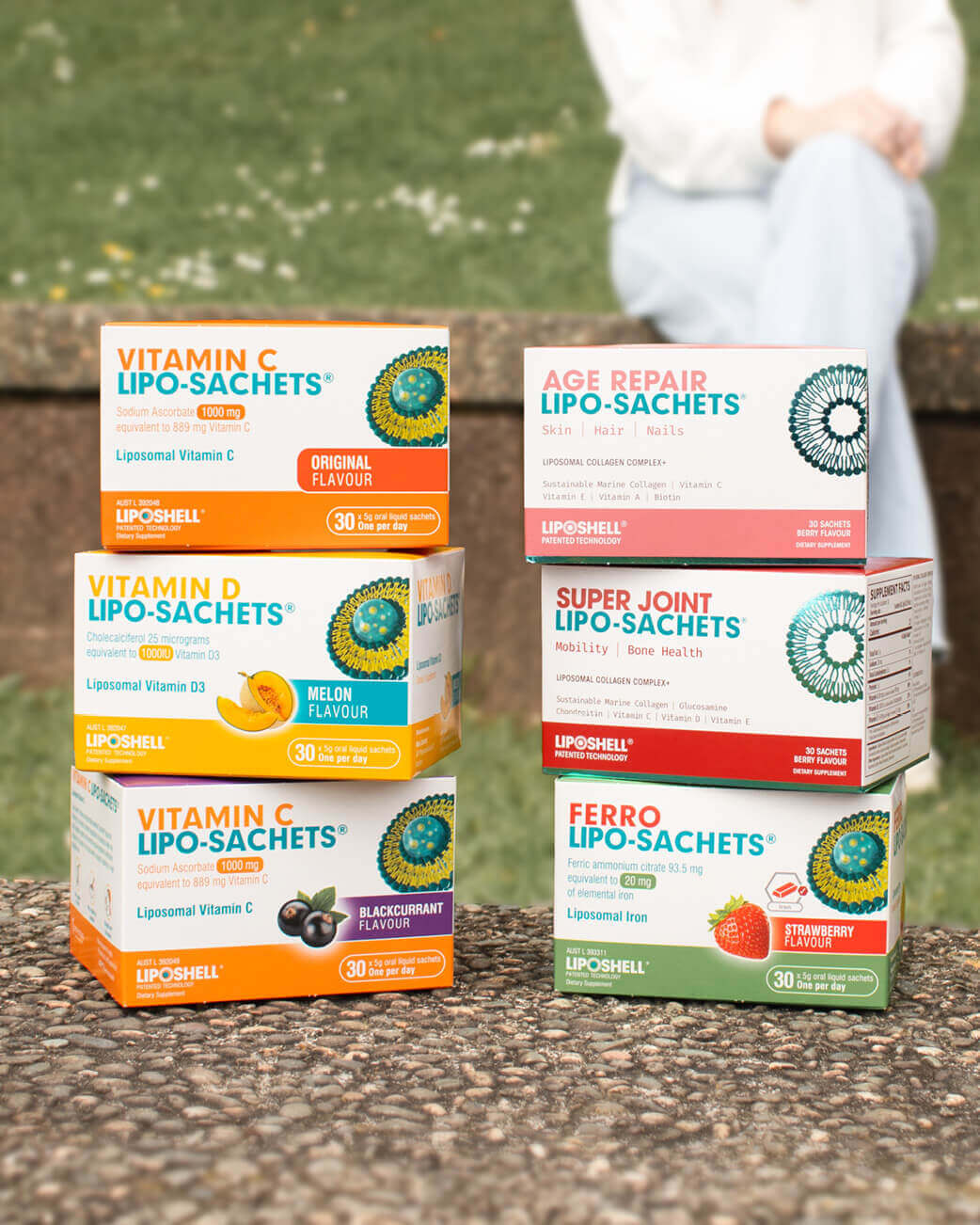 Collection of Lipo-Sachets boxes on a stone surface with a blurred outdoor background.