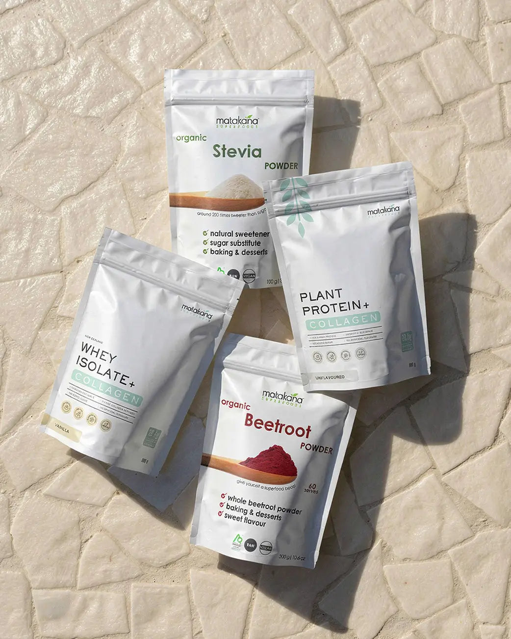 Four packages of Matakana Superfoods products on a textured stone surface.