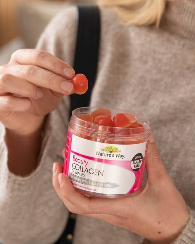 Person holding a container of Nature's Way Beauty Collagen gummies.