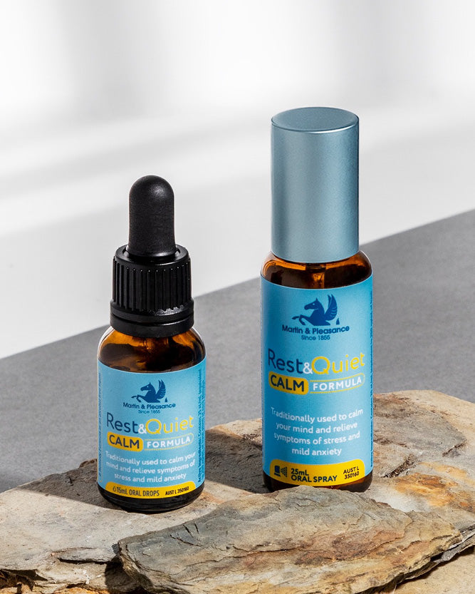 Two bottles of Rest & Quiet Calm Formula on a stone surface with a neutral background