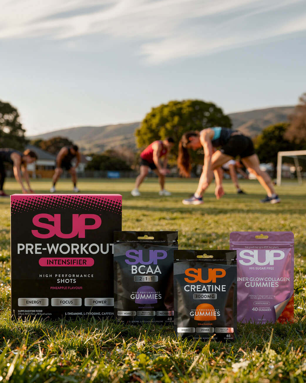Supplement packages on grass with people exercising in the background.