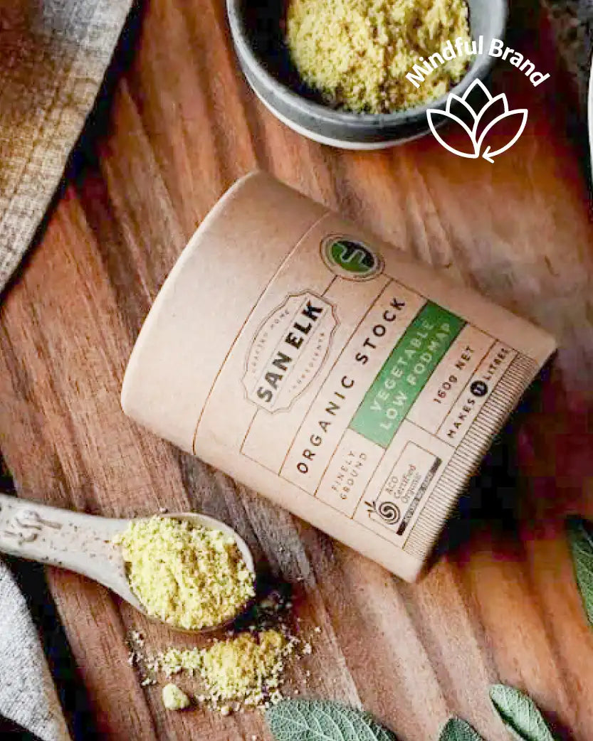 Sanelk organic stock powder on a wooden board with a spoonful of powder and 'Mindful Brand' logo.