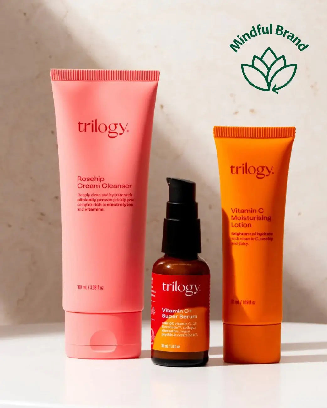 Three skincare products from Trilogy on a light background with 'Mindful Brand' logo.