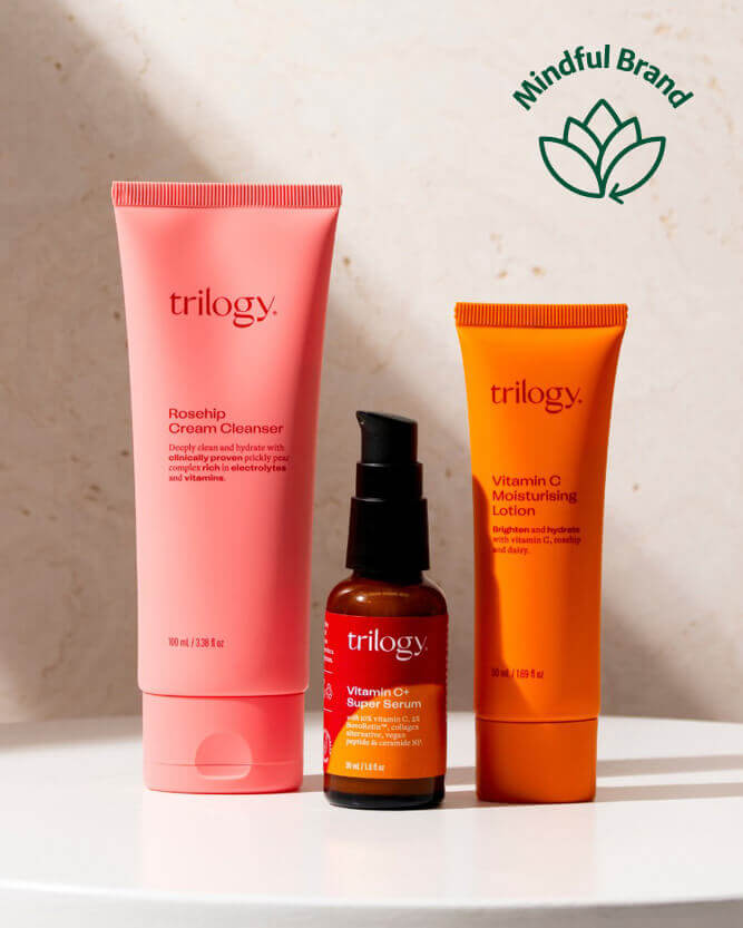 Three Trilogy skincare products on a light background with a mindful brand logo.