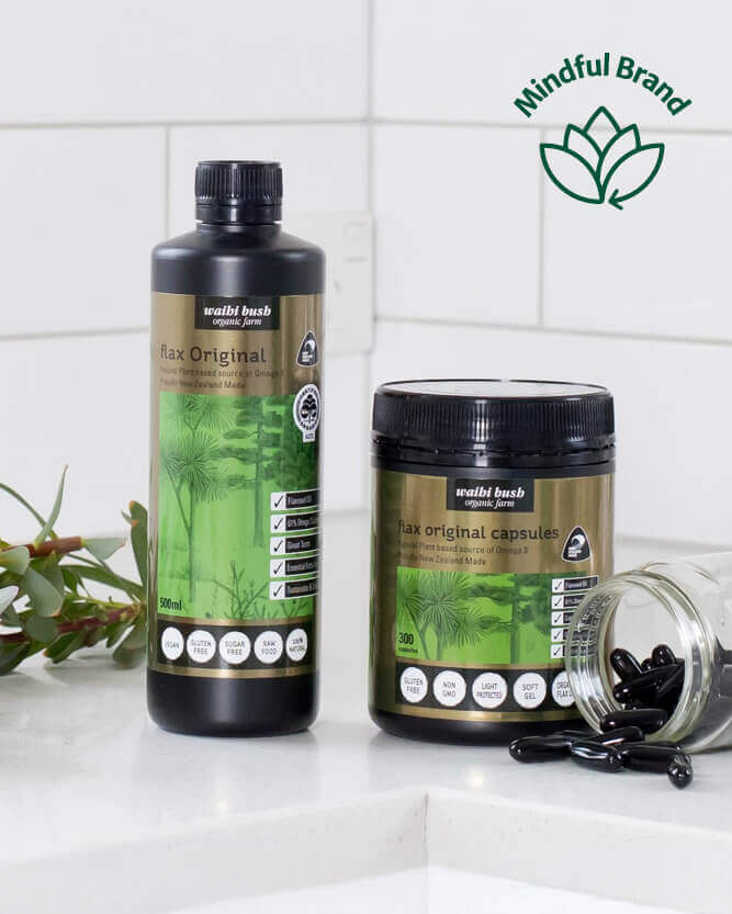 Two bottles of 'Wabi Bush' flax products on a white surface with a tiled wall background.