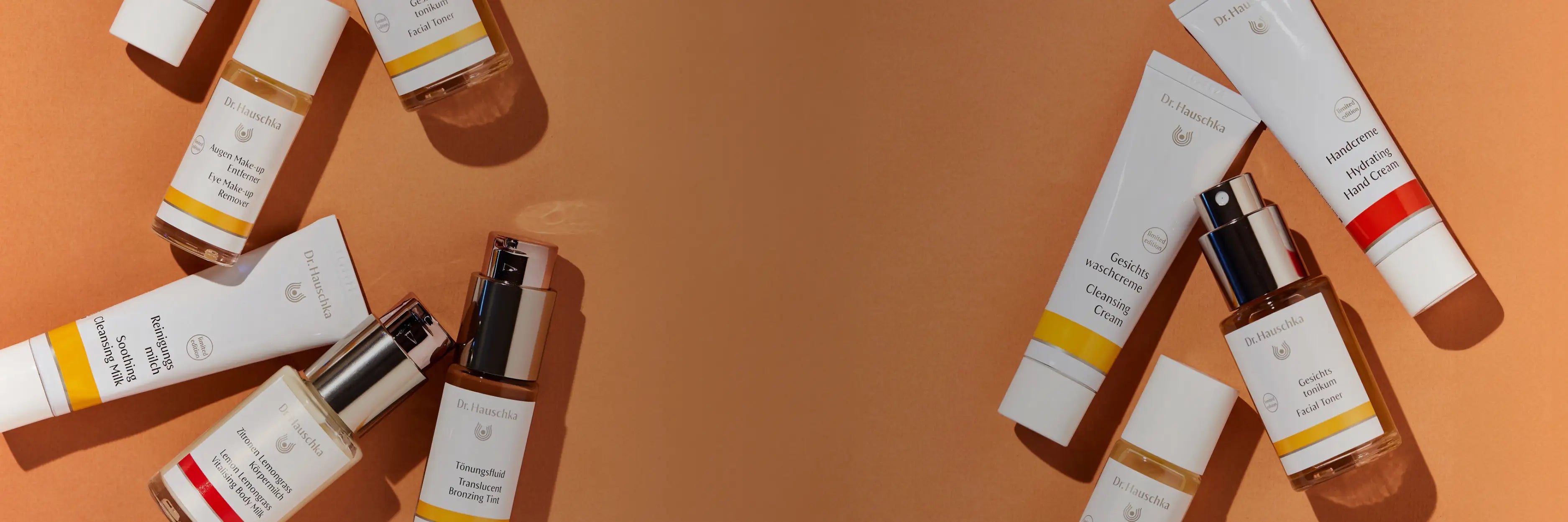 Dr. Hauschka products laid out on an orange surface.