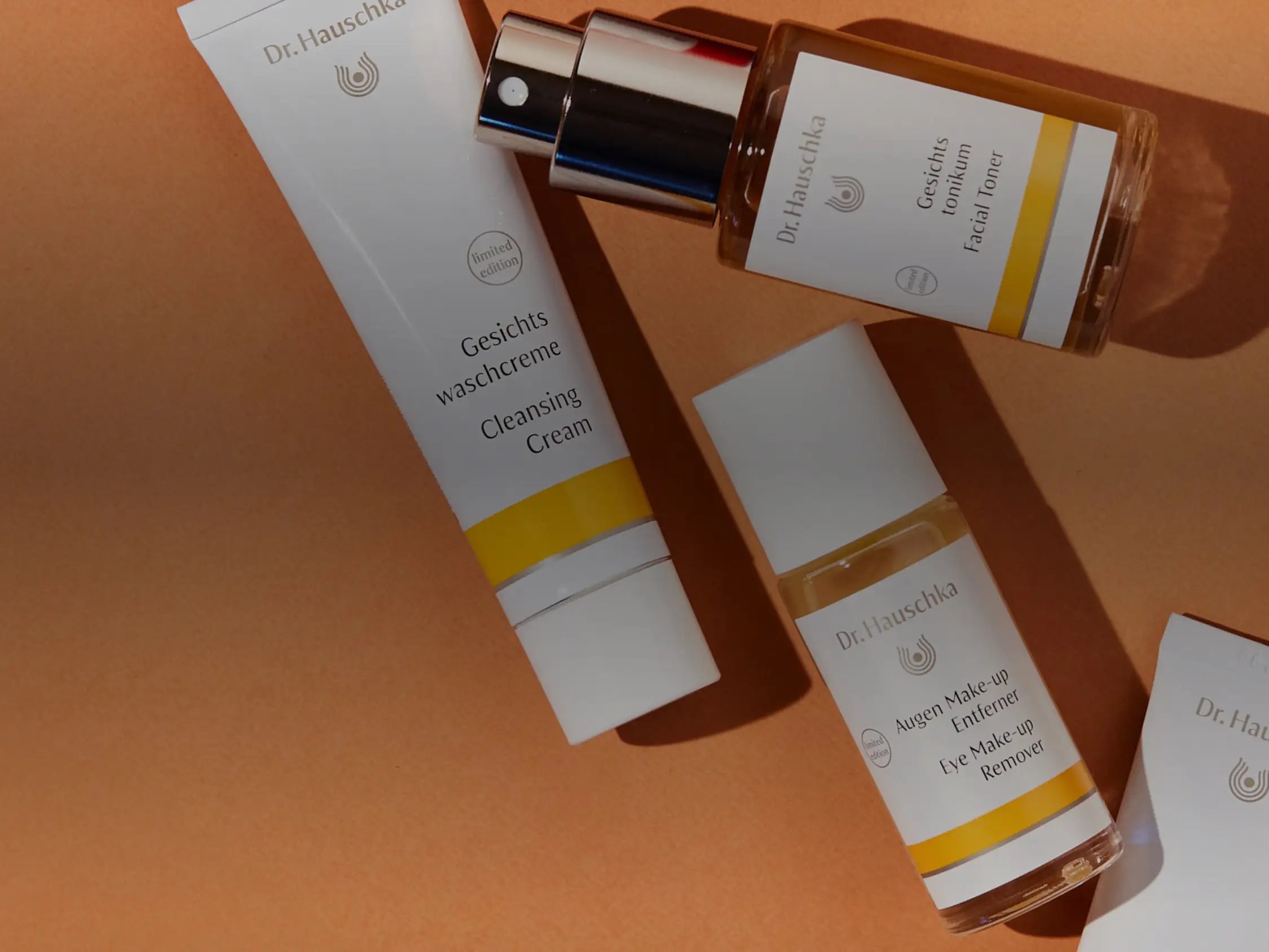 Dr. Hauschka products laid out on an orange surface.