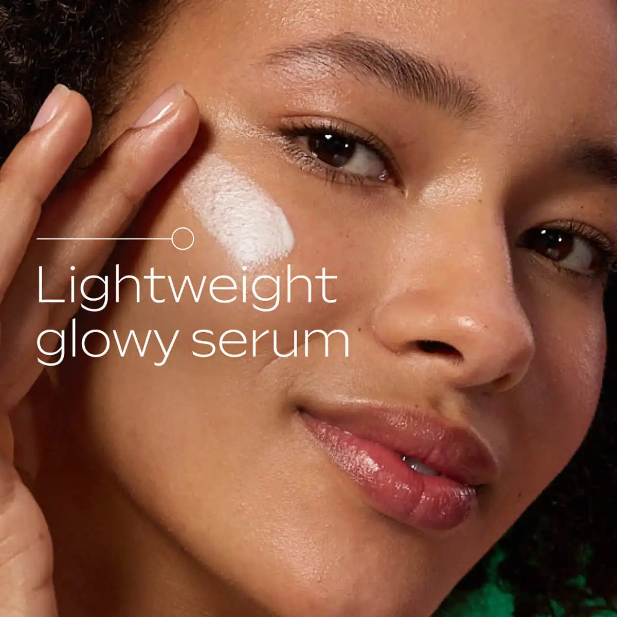 Woman applying skin food glow serum to her cheek.