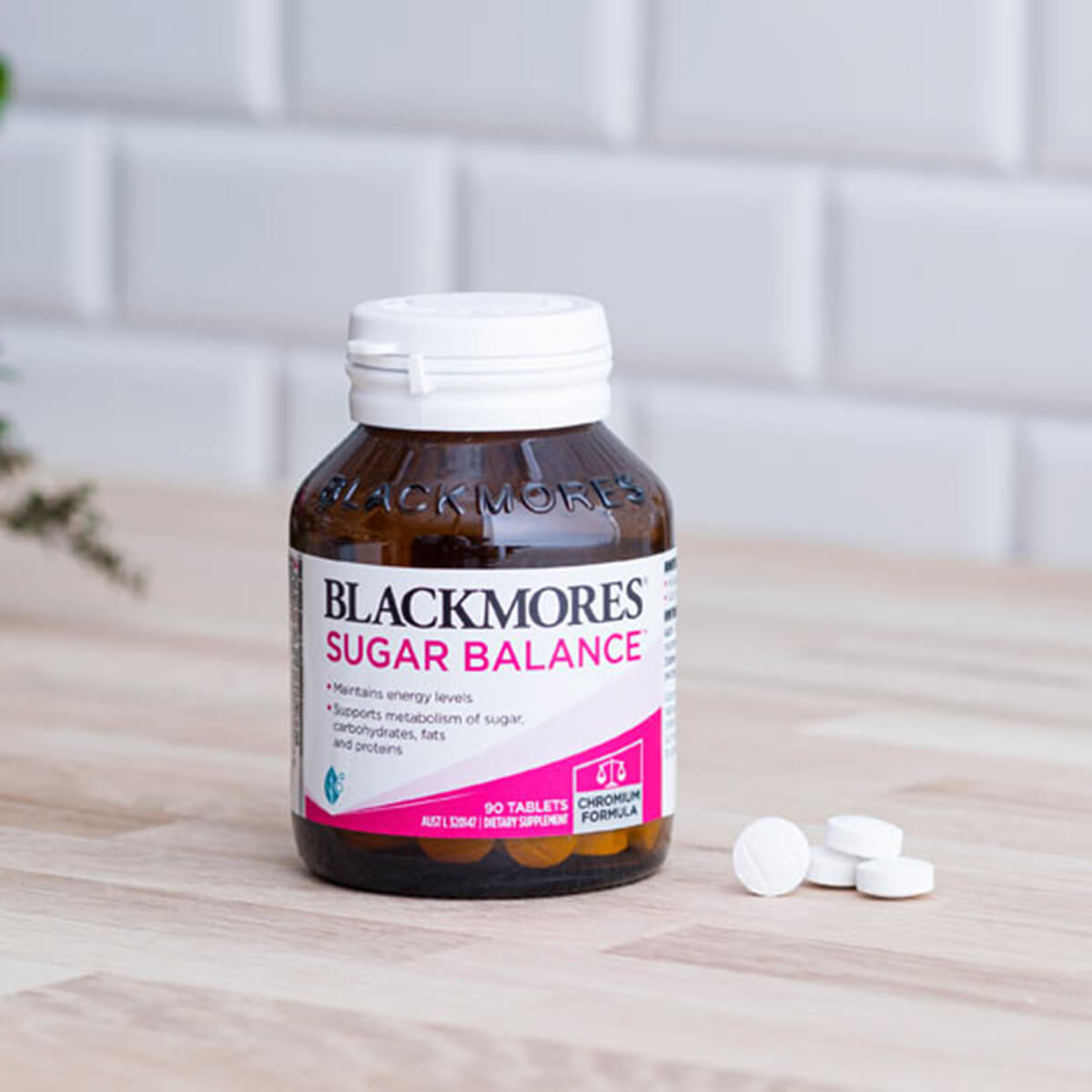 Blackmores Sugar Balance supplement bottle with tablets on a wooden surface.