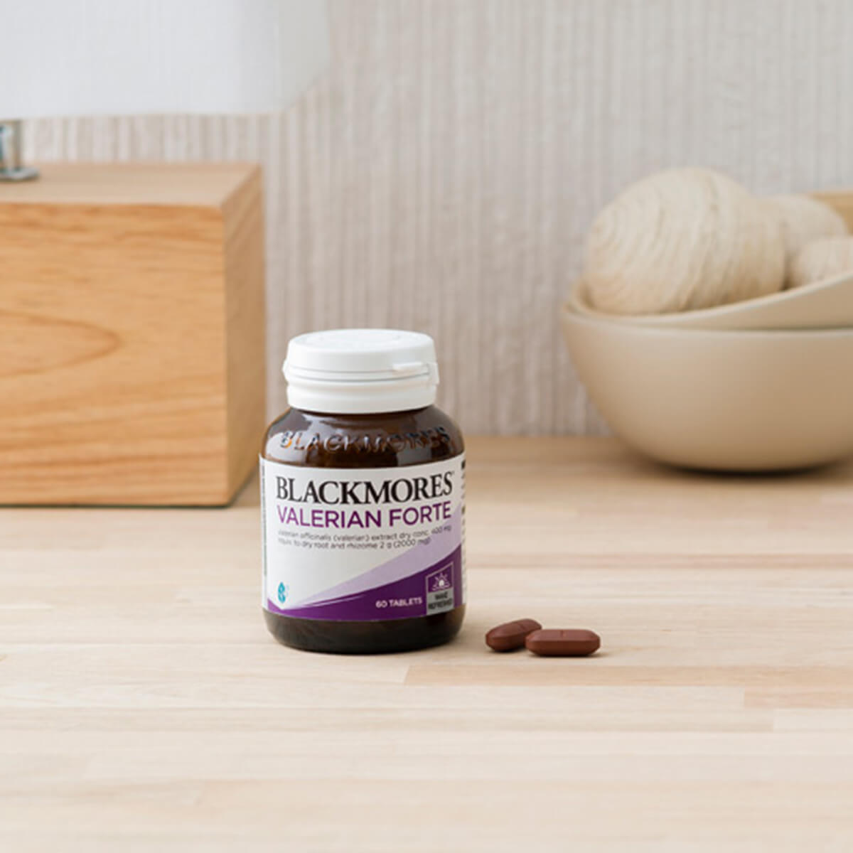 Blackmores Valerian Forte supplement bottle on a natural wood surface.