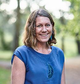 Woman wearing a blue shirt with a leaf design outdoors