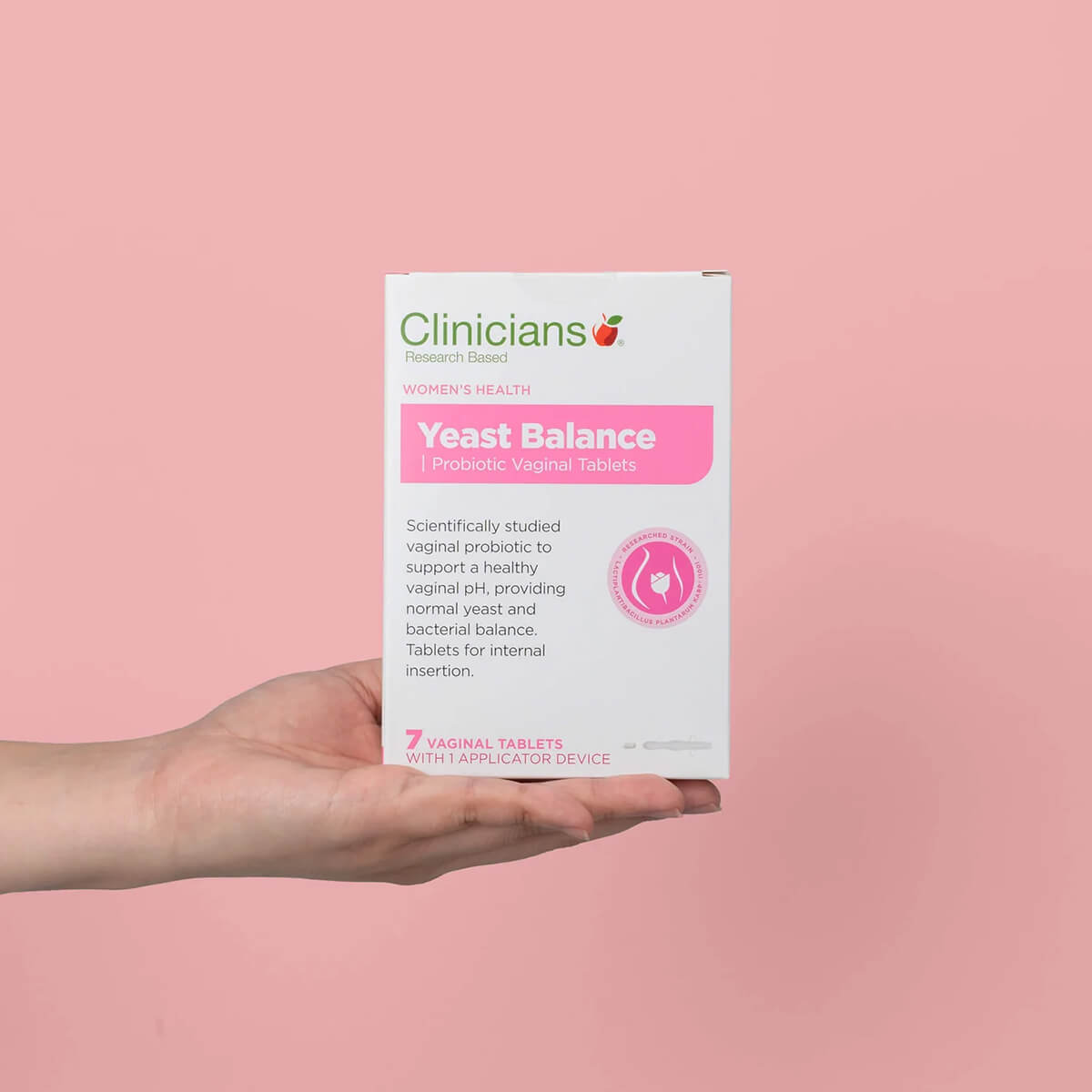 Clinicians Yeast Balance Probiotic Vaginal Tablets packaging held in a hand against a pink background.