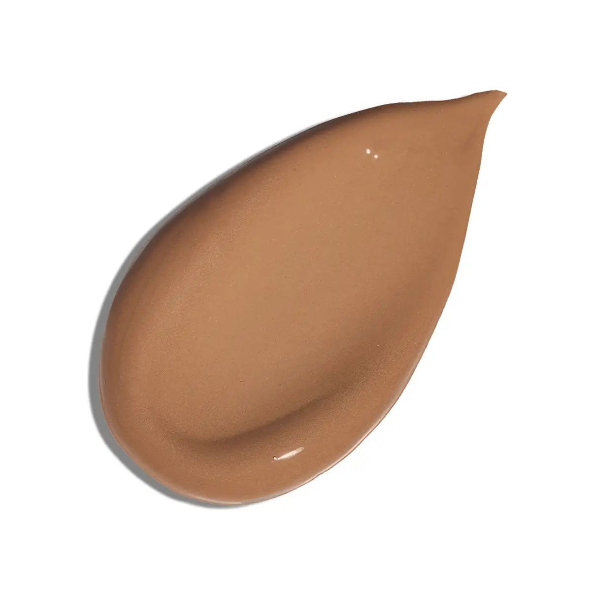A teardrop-shaped smear of liquid foundation in a warm medium tan shade, shown on a clean white background.