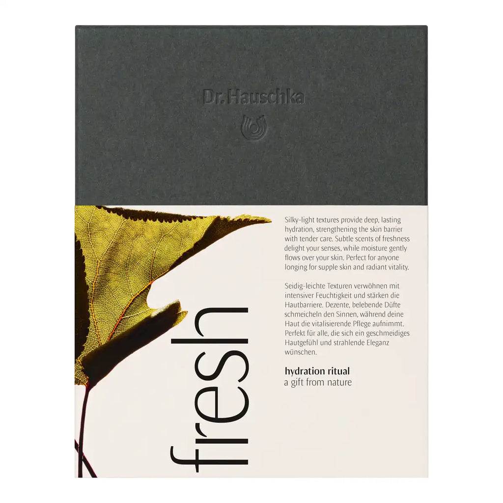 Dr. Hauschka Fresh Gift Set, featuring a dark gray top section with the brand name and a lower cream-colored section with text and a leaf graphic.