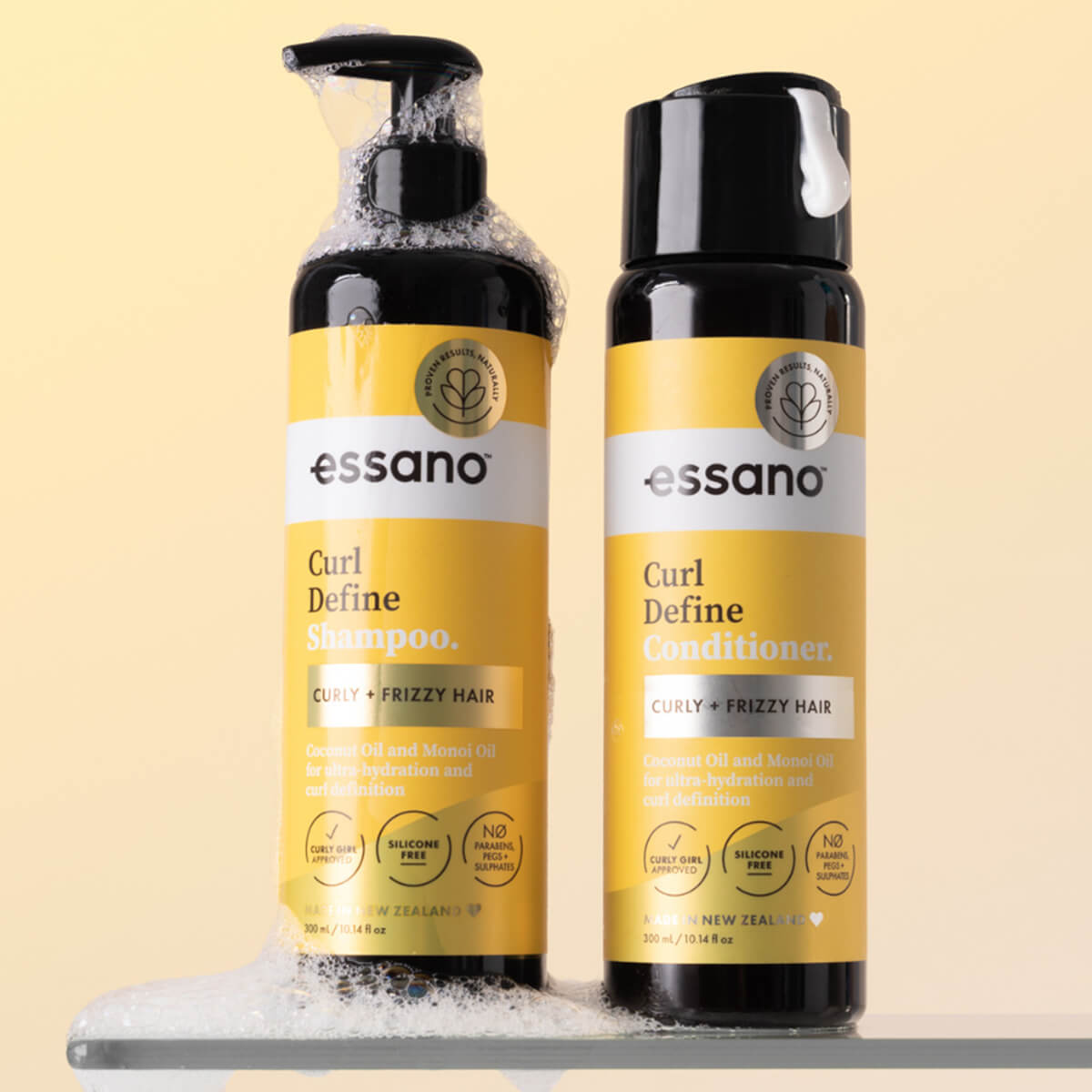 Essano Curl Define Shampoo and Conditioner bottles on a beige background.