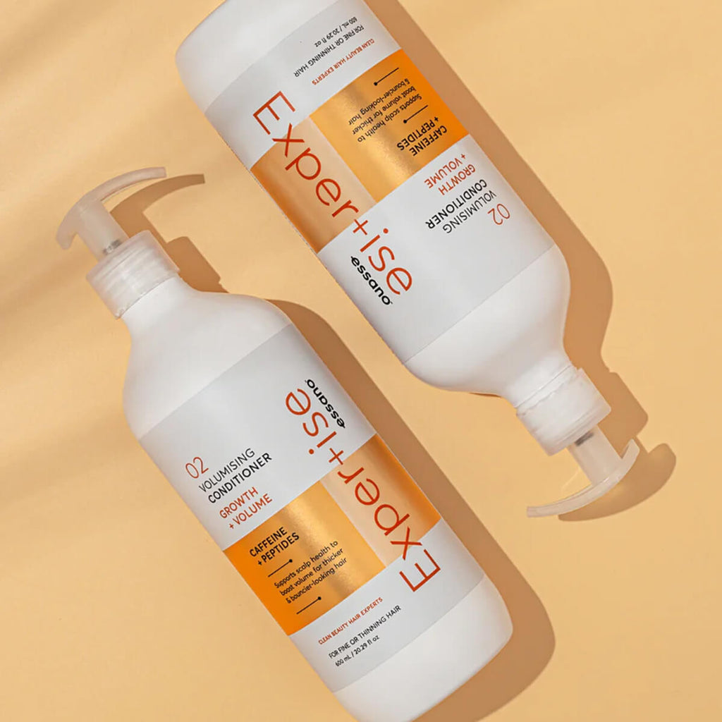 Two bottles of 'Expertise' hair care products on a beige background.