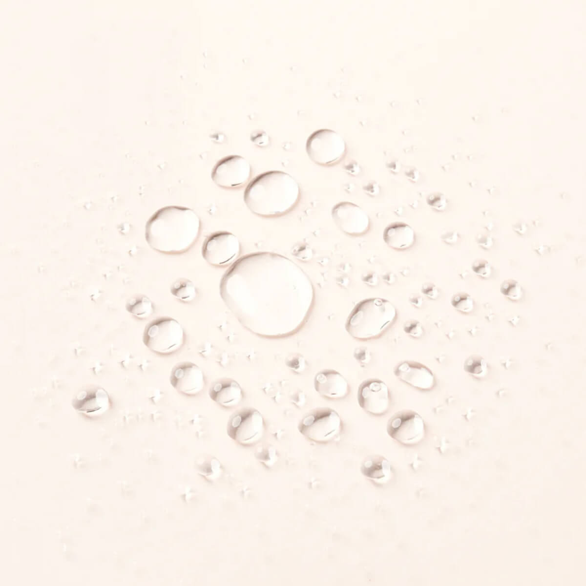 Water droplets on a light pink background.