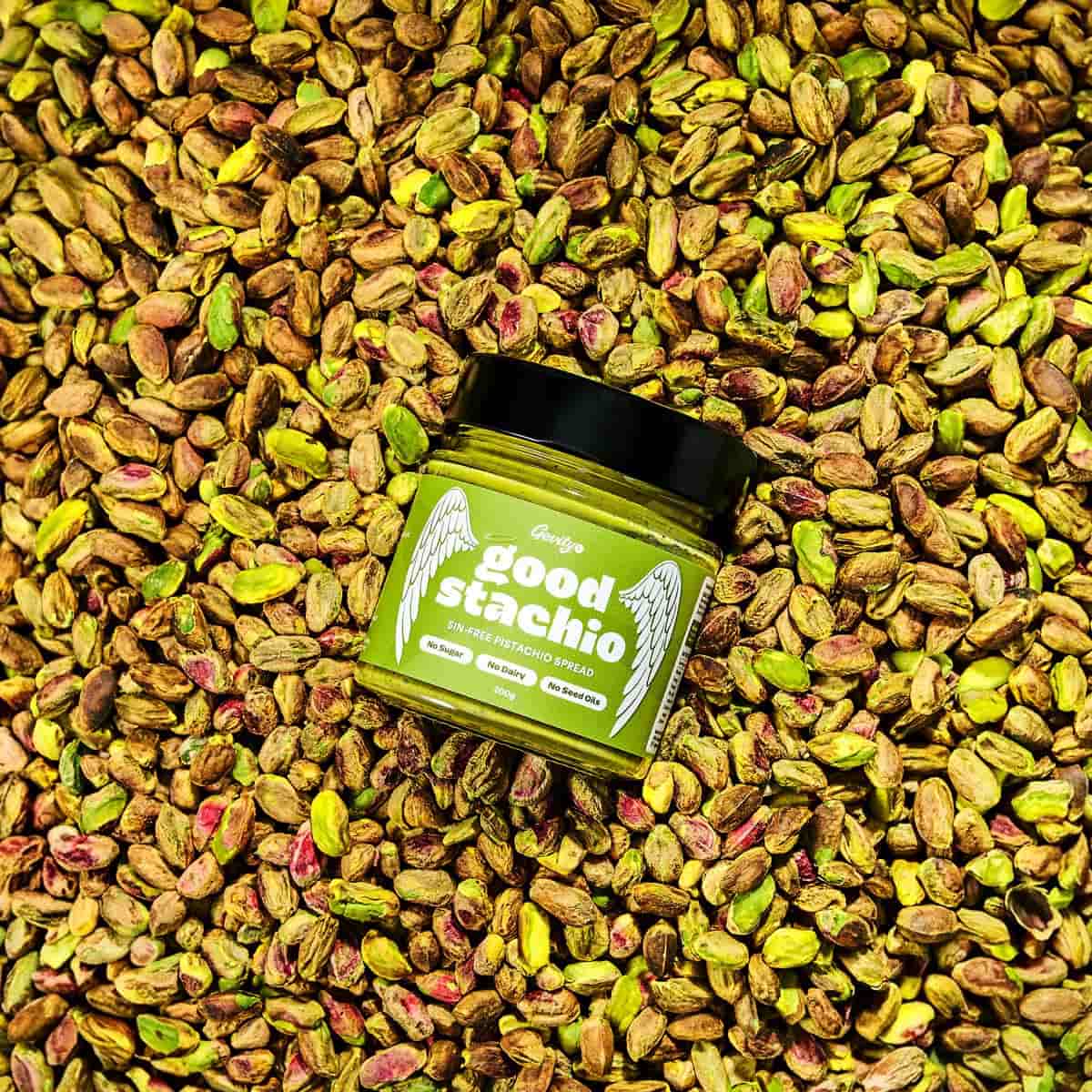Jar of 'goodstachio' surrounded by pistachios.
