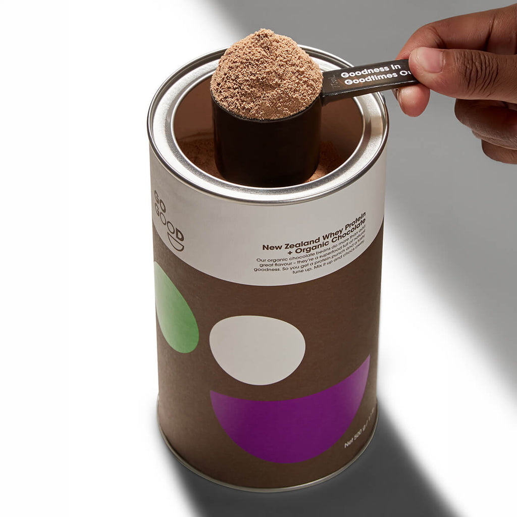 Canister of New Zealand White Pea Protein with a scoop of powder held above it.