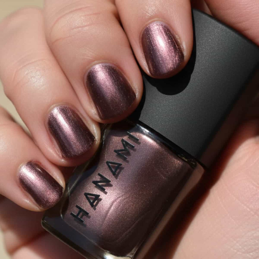 Nail polish with metallic finish held by a hand, brand 'HANAMI' visible.
