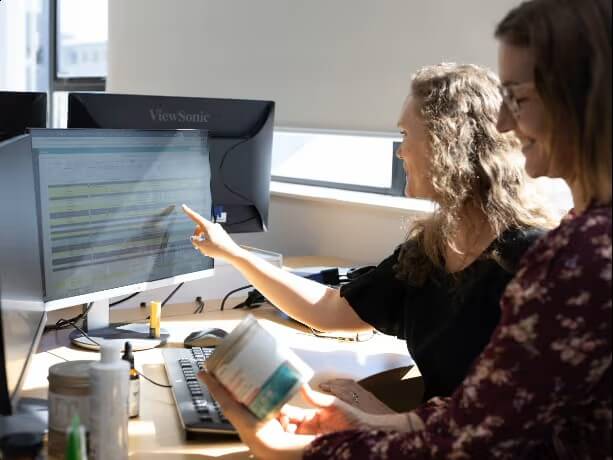 HealthPost team reviewing documents and products at a computer.