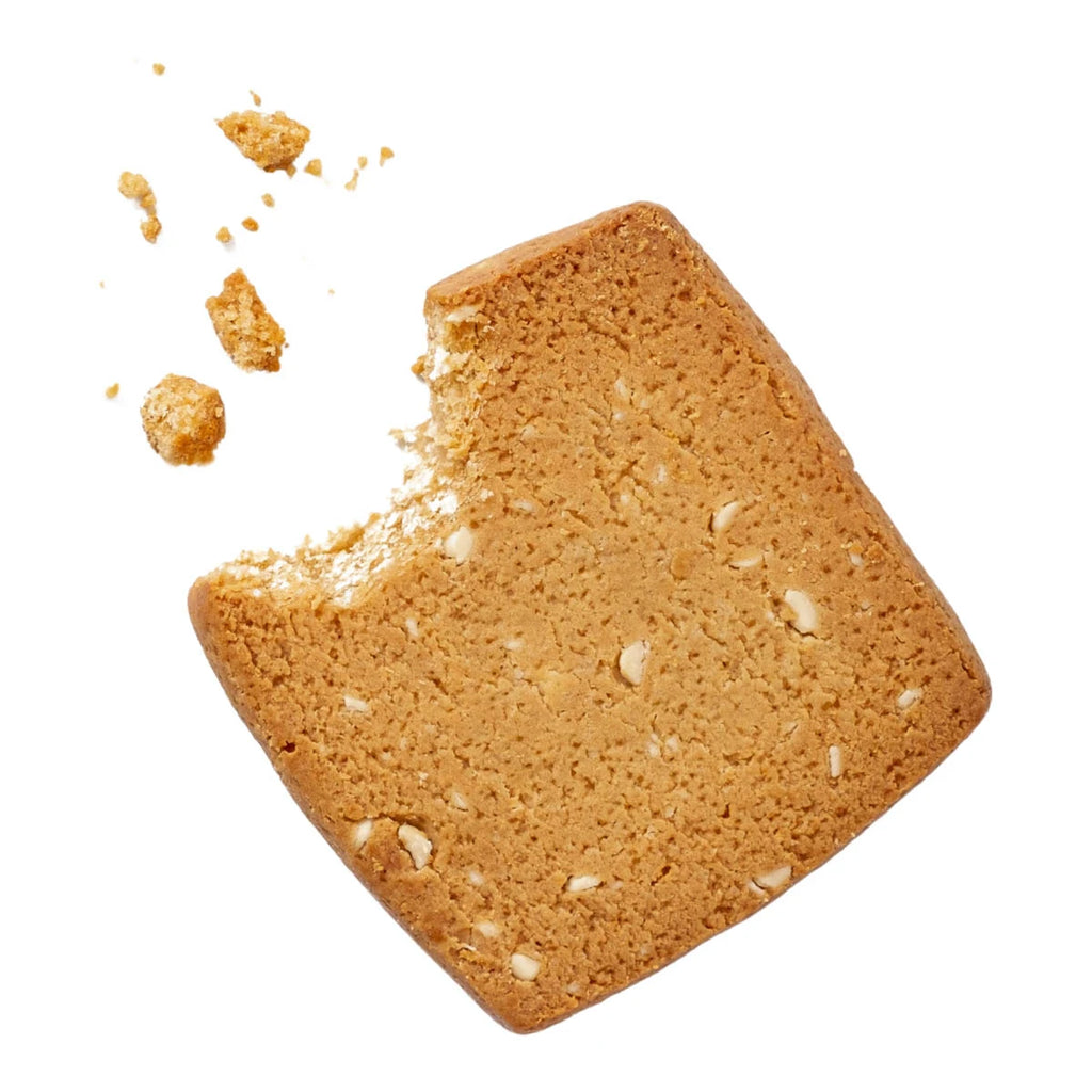 Square piece of brown cookie with crumbs on a white background