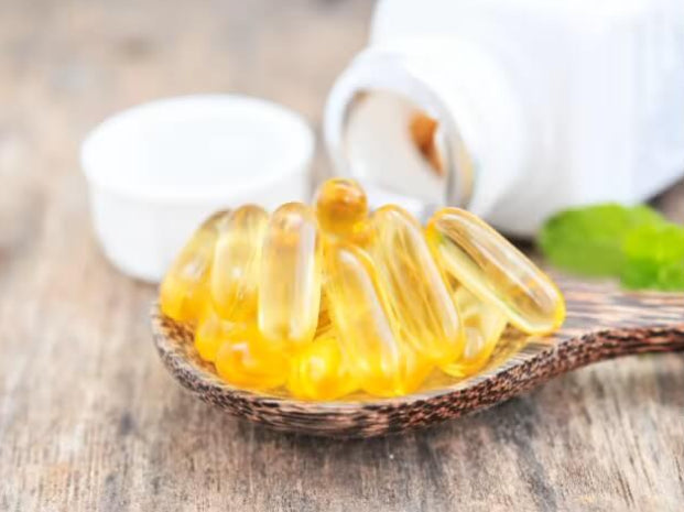 fish supplement capsules in a spoon